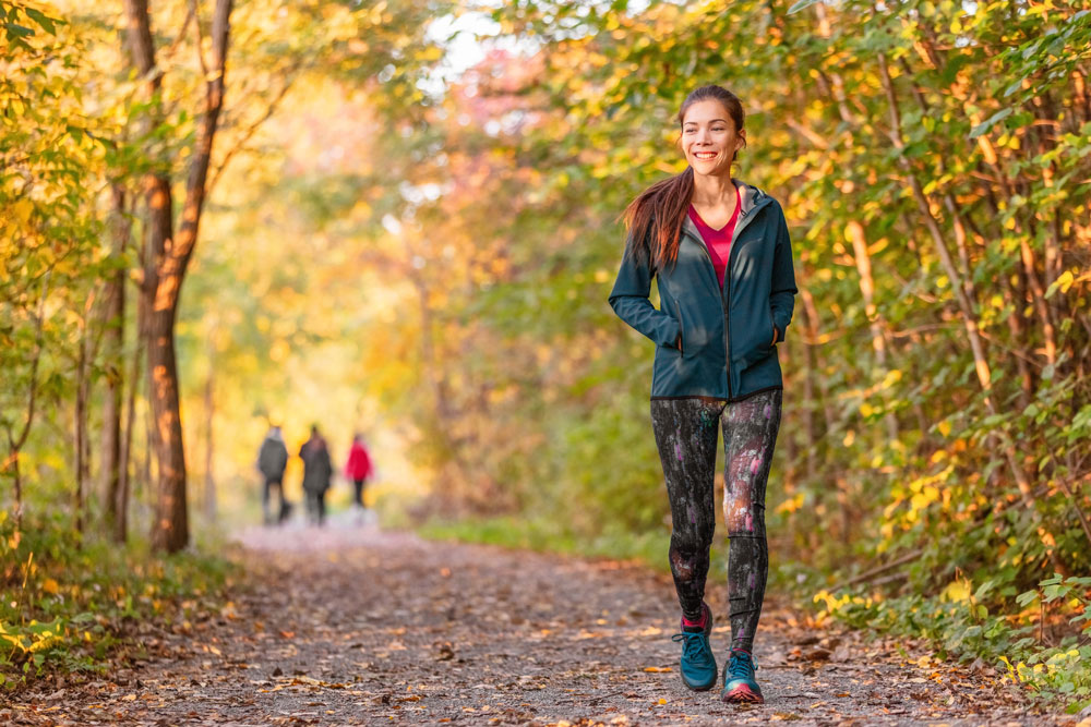 woman happily walking on a forest path